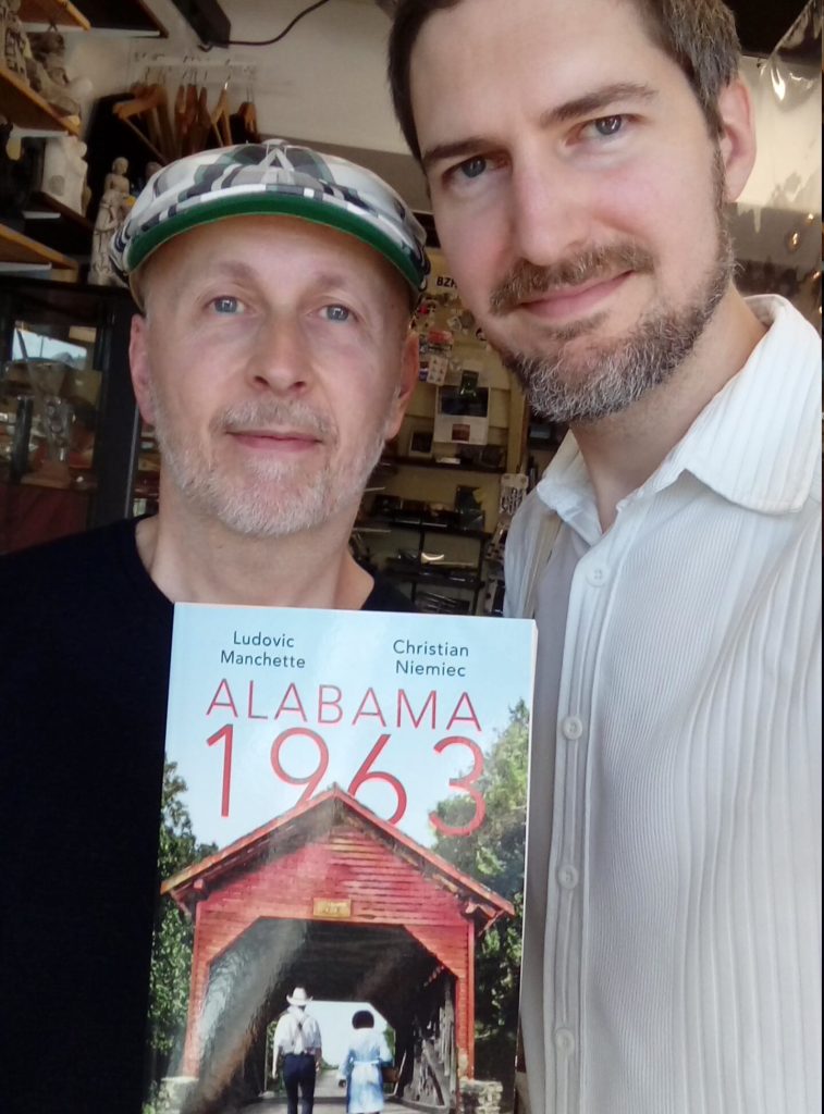 Christian Niemiec et Ludovic Manchette tenant pour la première fois leur roman Alabama 1963 entre leurs mains.